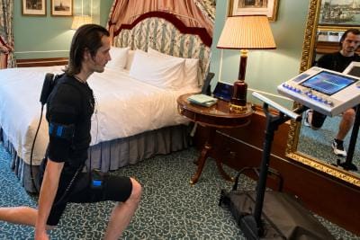 Man using EMS technology to exercise in his hotel room