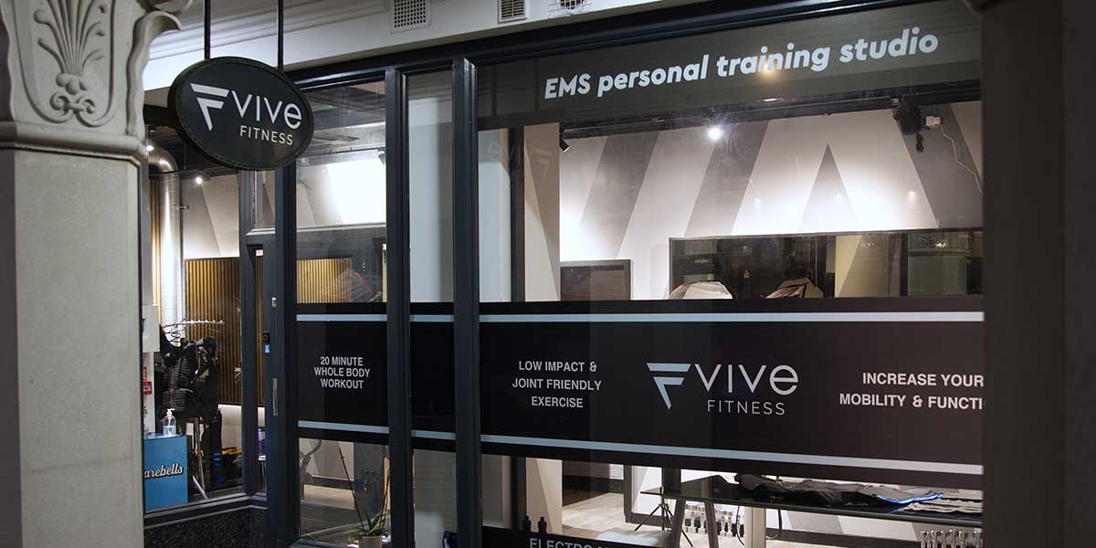 The exterior of the Vive Fitness EMS personal training studio in Richmond, London, showcasing branded window decals and the studio entrance.